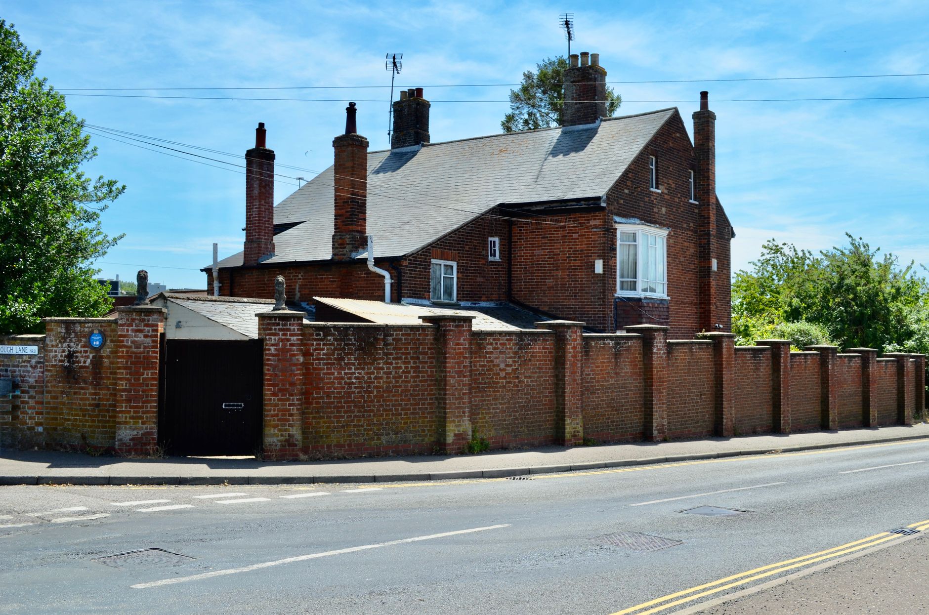 Traditional British red brick house with a matching boundary wall